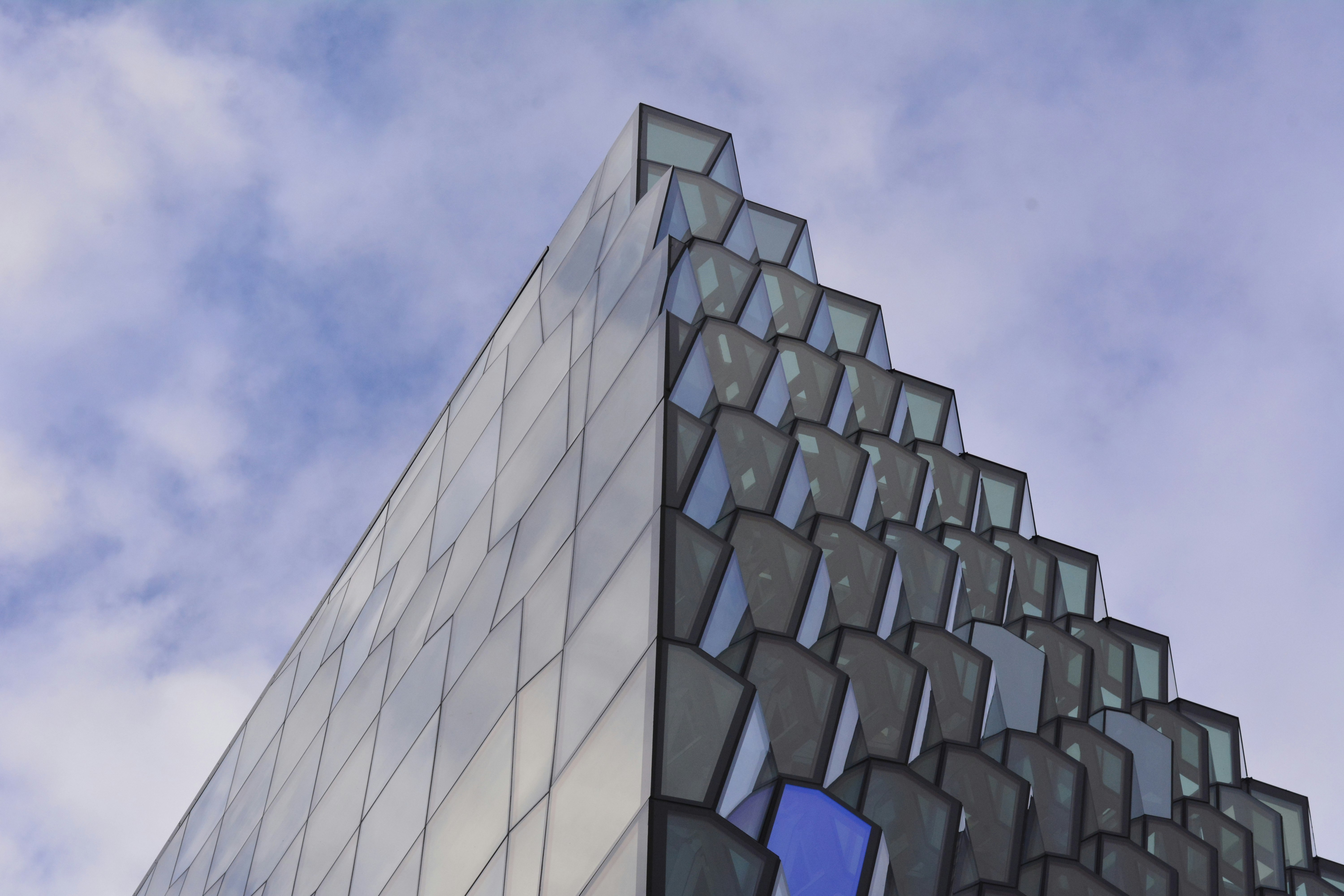 low angle photography of glass building under cloudy sky at daytime